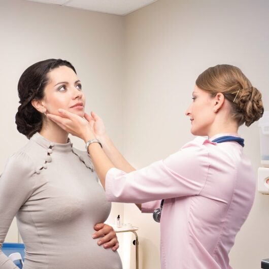 Doctor endocrinologist checking thyroid pregnant
